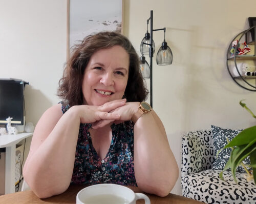 Picture of Terri at a table, ready for a chat.